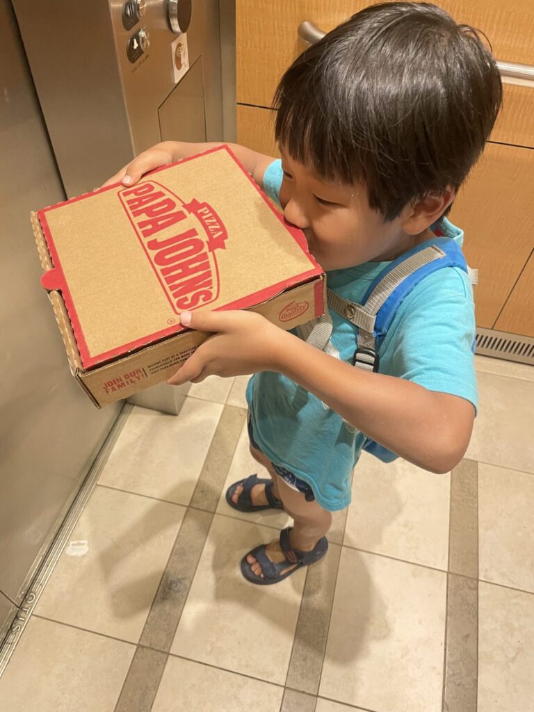 ピザの匂いを嗅ぐ子供
